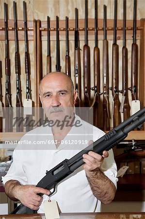 Portrait of a mature gun merchant with rifle