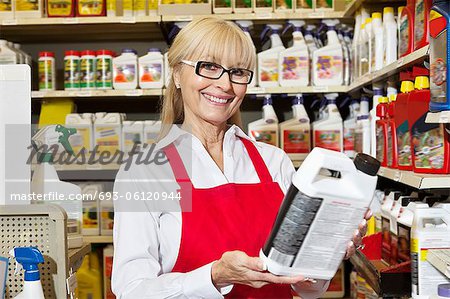 Portrait of a senior woman holding can in retail store