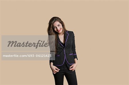 Portrait of beautiful young woman in formals over colored background