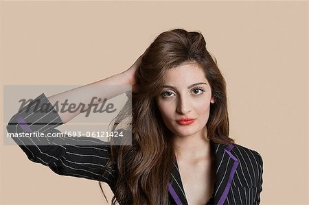 Portrait d'une belle jeune femme avec une main dans les cheveux sur fond coloré
