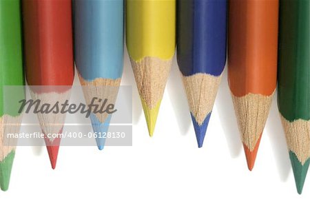 coloured pencils with pointed tips on a white background casting soft shadows
