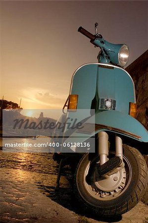 Vespa parked nearby the lake at the sunset