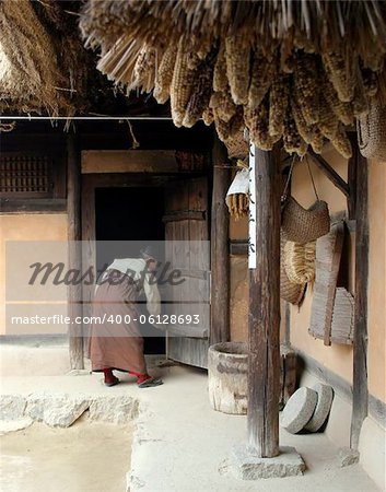 Korean woman cleaning a traditional house at Suwon Folk Village, South Korea