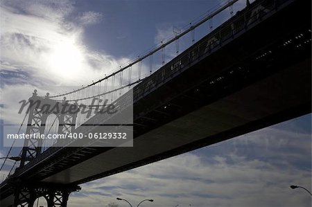 Brooklyn Bridge spanning the east river, viewed from underneath and into the sun, Manhattan, New York, America, usa