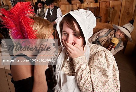 Two ladies whisper to each other as drunk cowboy listens