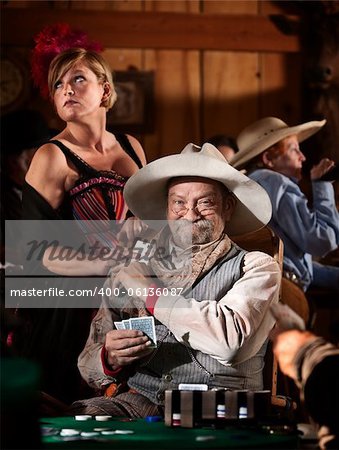 Sneaky old poker player gets winning card from showgirl in saloon
