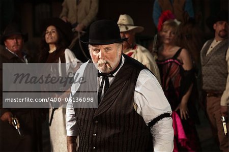 Mean looking man with cigar in old American west costume