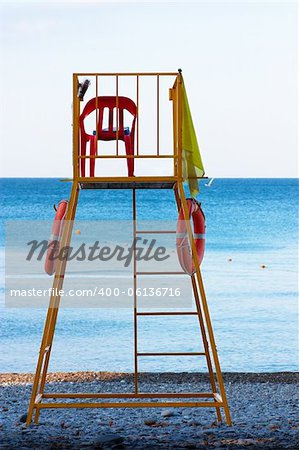 Empty lifeguard chair on the beach with life buoys