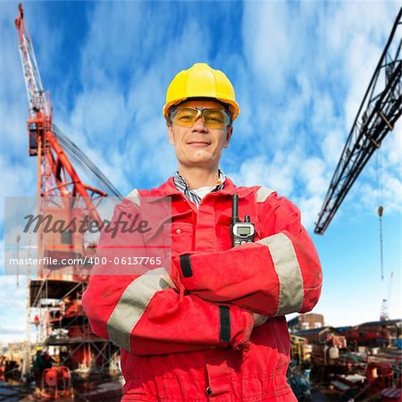 Offshore engineer, looking proudly, standing on the deck of an industrial vessel at the docks