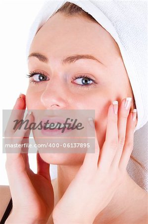 Young woman with smooth skin and white tower touch her face by finger with nice manicure