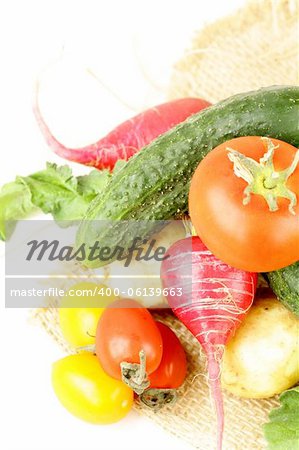 various vegetables (tomatoes, radishes, cucumbers) on a white background