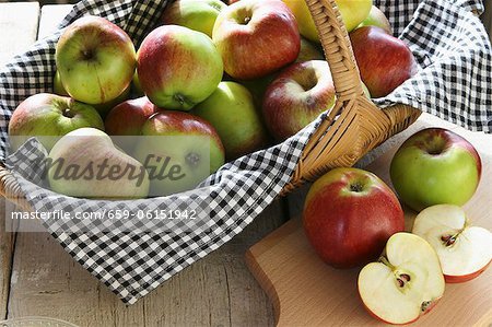 A basket of organic apples and sliced apples on a board