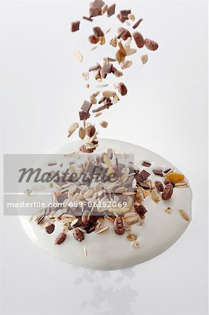 Muesli falling into a splash of yogurt