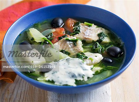 Fish soup with spinach, olives and basil yogurt