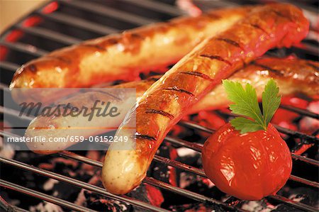 Grilled sausages and tomatoes on a barbeque