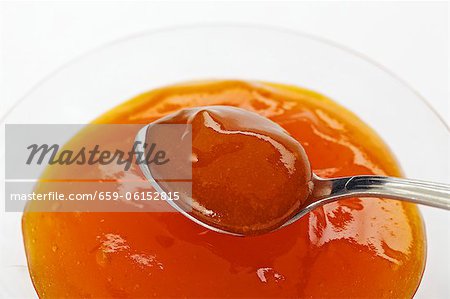 Apricot jam in a bowl and on a spoon