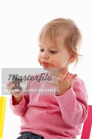 Un petit enfant de manger une guimauve au chocolat