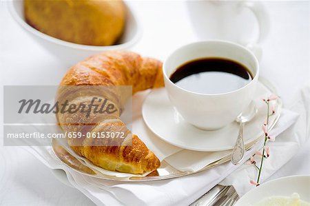 Une tasse de café et un croissant