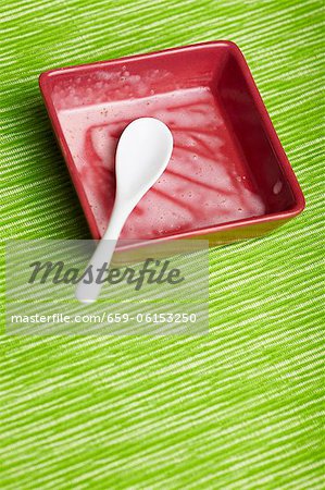 Restes de la crème glacée dans un bol avec une cuillère Restes de la crème glacée dans un bol avec une cuillère