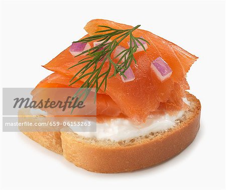 Slice of Bread Topped with Cream Cheese and Smoked Salmon; Red Onion and Dill; White Background