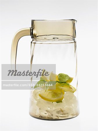 Glass carafe with lemons, mint and ice cubes