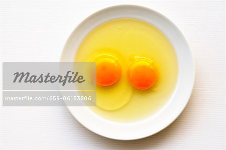 Deux œufs fêlés sur une plaque (vue de dessus)