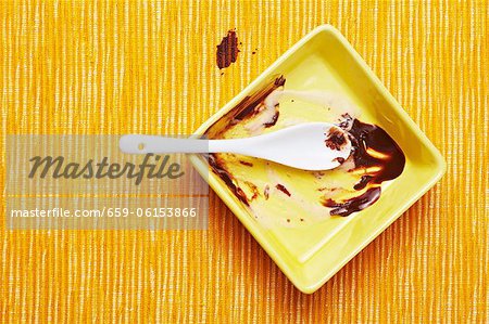 Les restes de la crème glacée et sauce au chocolat avec une cuillère Les restes de la crème glacée et sauce au chocolat avec une cuillère