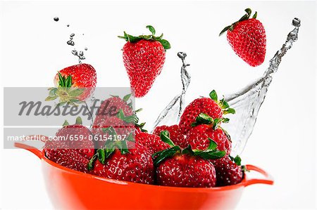 Fraises fraîches et les éclaboussures d'eau ; Dans un bol