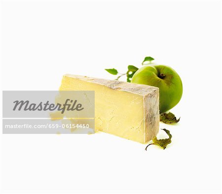 Un morceau de fromage à pâte dure et une pomme verte