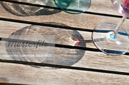 Shadows of wine glasses on a wooden surface