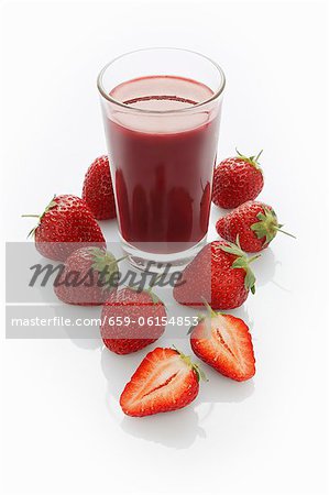 A jar of strawberry smoothie and fresh strawberries