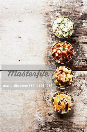 Plats d'accompagnement barbecue dans des petits bols sur une Table en bois ; Porc et haricots, salade de pommes de terre, salade de chou et Succotash Plats d'accompagnement barbecue dans des petits bols sur une Table en bois ; Porc et haricots, salade de pommes de terre, salade de chou et Succotash