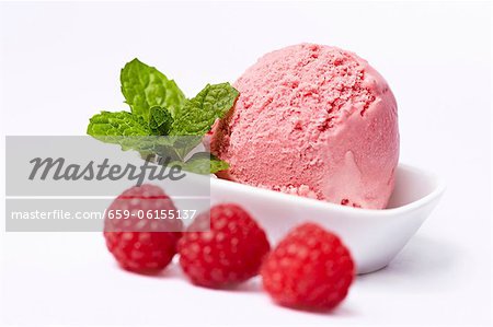 A scoop of raspberry ice cream and fresh raspberries