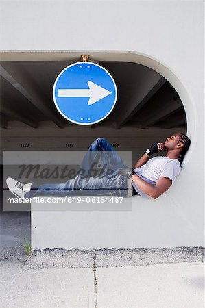 Man sitting on ledge on city street