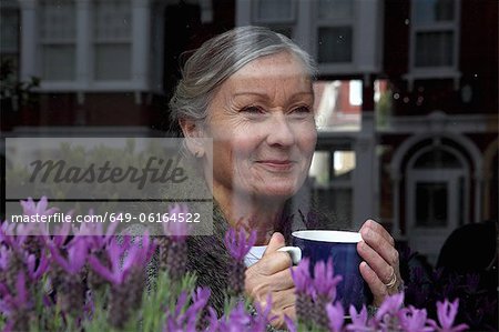 Woman drinking coffee at window