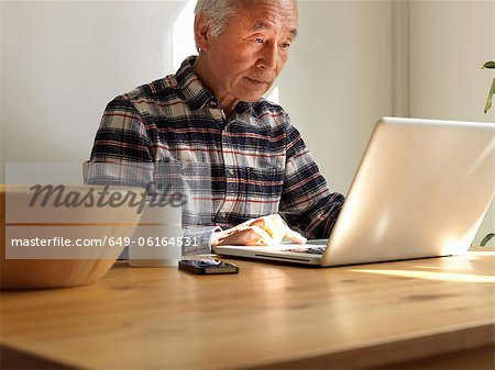 Older man using laptop at table