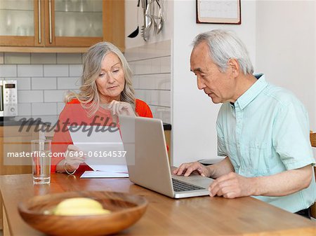 Older couple paying bills online