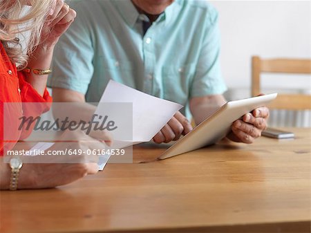 Older couple reading mail in kitchen