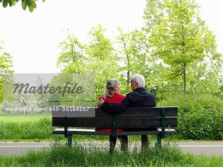 Older couple sitting on park bench