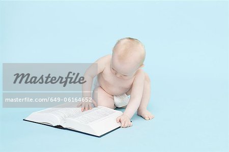 Baby boy playing with book