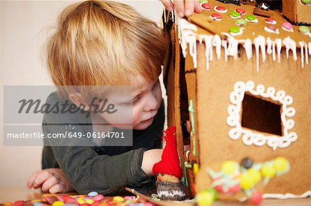 Boy decorating gingerbread house
