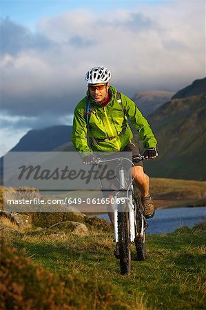 Mountain biker on grassy hillside