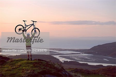 Vélo holding homme sur la colline