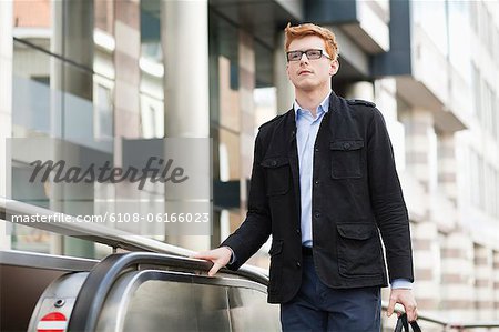 Businessman standing on escalator