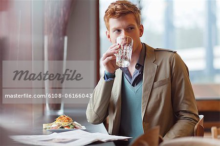 Mann sitzt in einem Restaurant und Trinkwasser