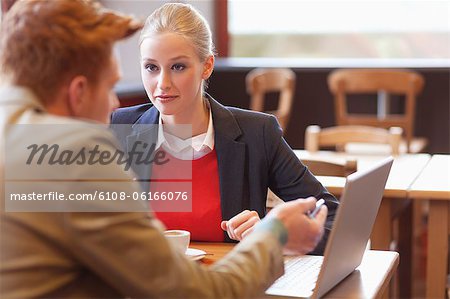 Couple sitting in a restaurant working on a laptop