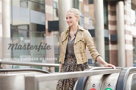 Businesswoman standing on escalator