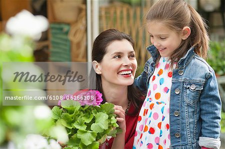 Femme et sa fille regardant les fleurs dans un magasin de fleurs