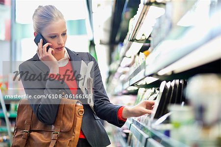 Woman in a supermarket talking on a mobile phone Woman in a supermarket talking on a mobile phone