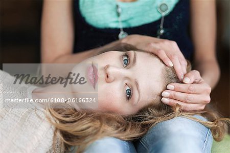 Woman lying on her mother's lap